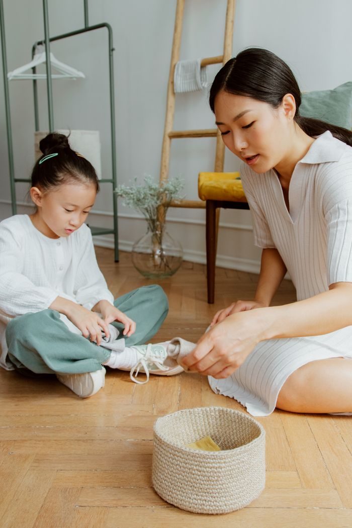 Crafting Captivating Headlines: Your awesome post title goes here Mother and daughter sitting on the floor organizing items at home, fostering family bonding.